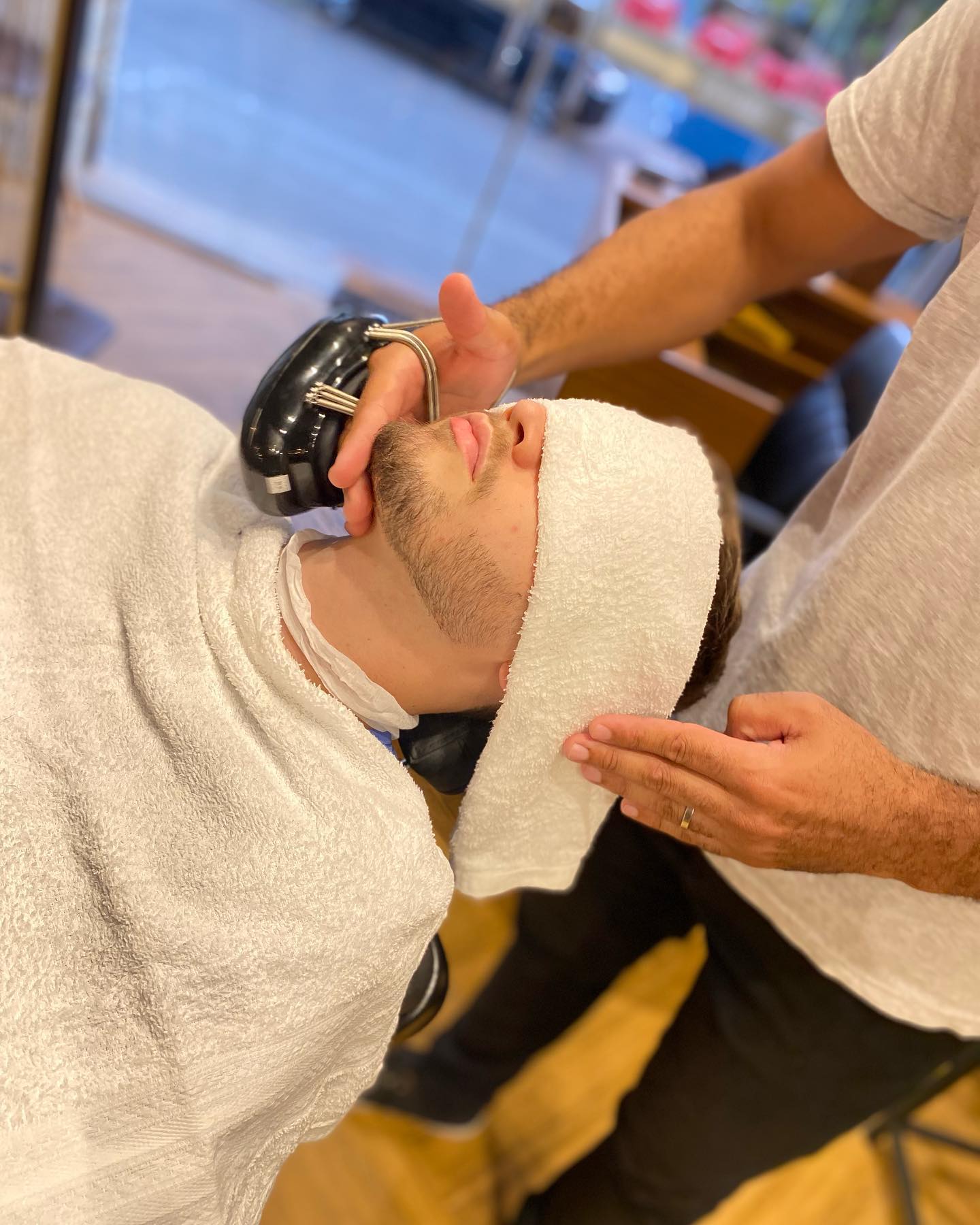 Atendimento de barba com toalha na Barbearia George Fiuza